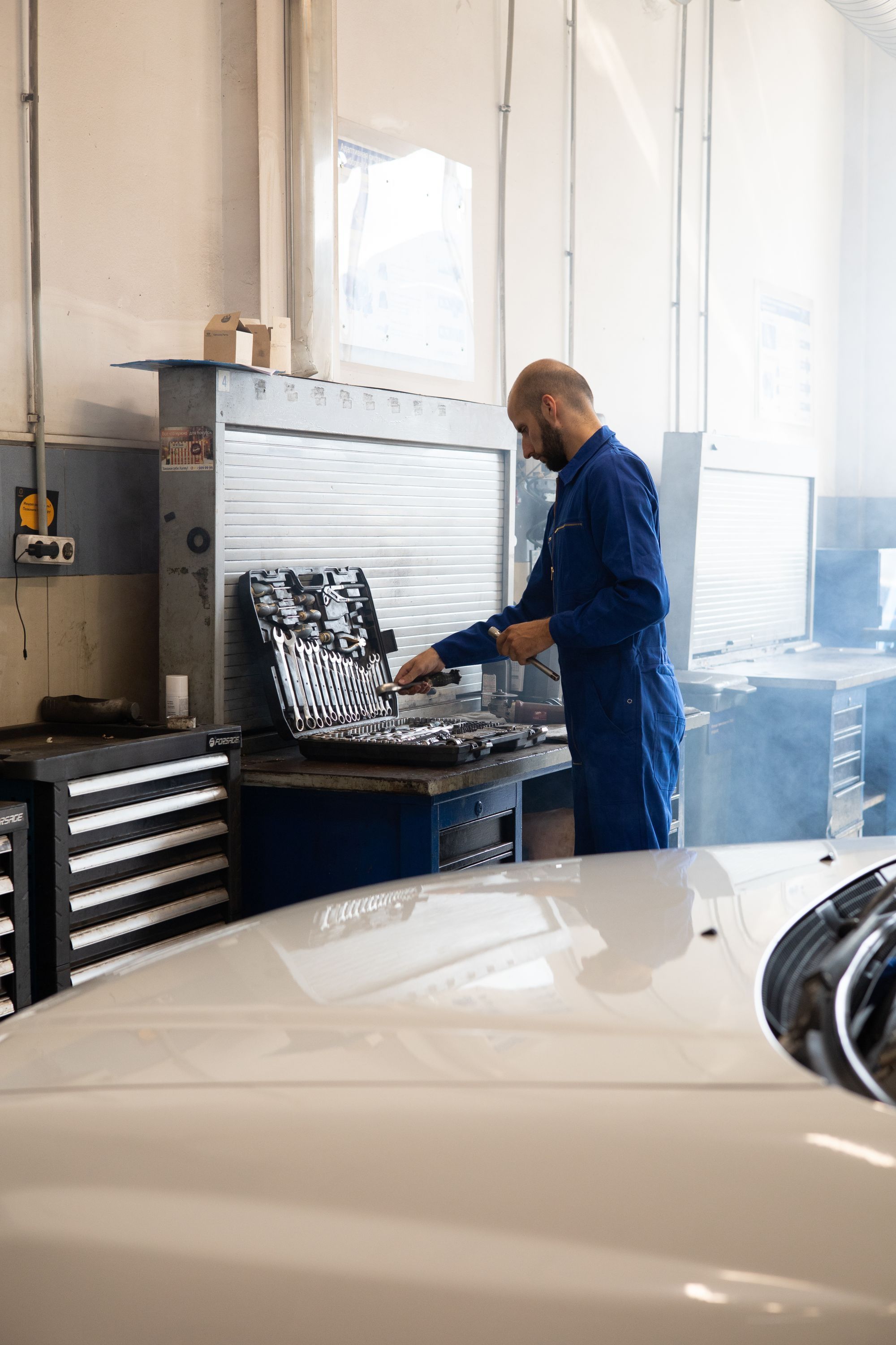 Mechaniker arbeitet in einer Werkstatt an einem Fahrzeug