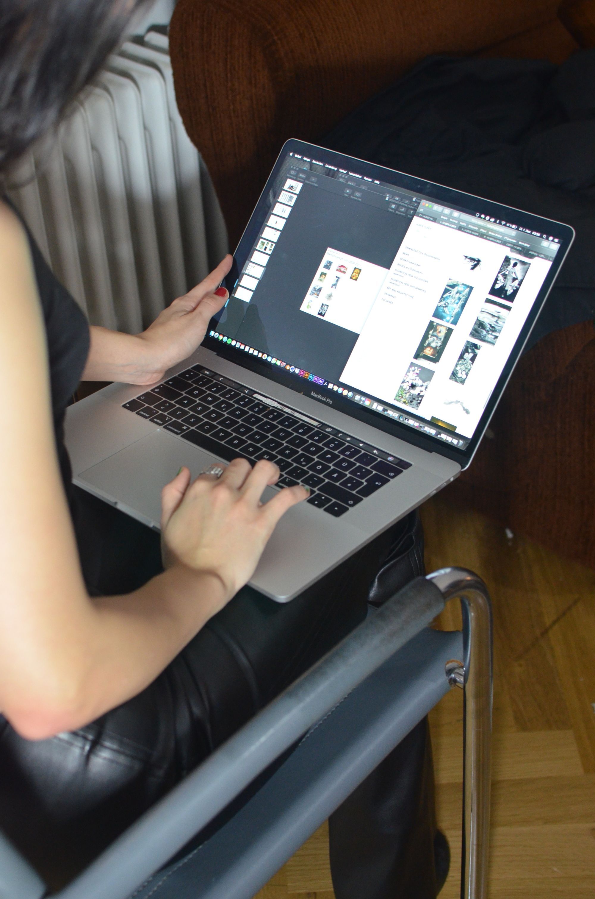 Hände tippen auf einem Laptop auf einem dunklen Ledersessel
