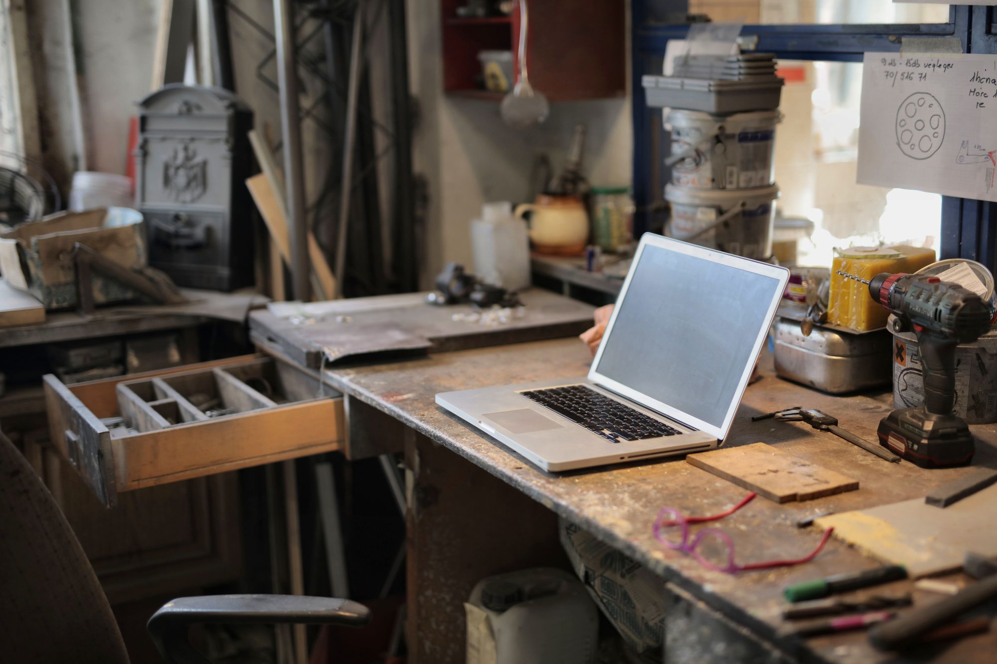 Laptop auf einer Werkbank zwischen Werkzeugen