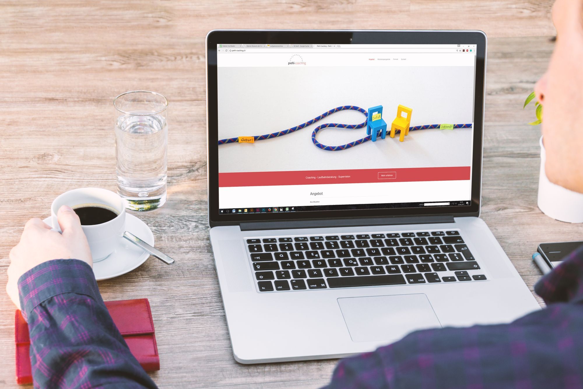 Laptop mit geöffneter Website neben einer Kaffeetasse